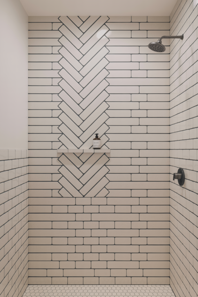 White subway tiles in a herringbone pattern with dark charcoal grout on a basement bathroom shower wall with a matte black recessed niche and showerhead